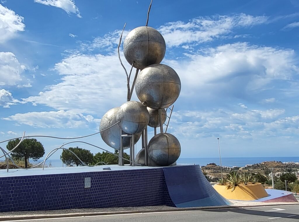 A towering contemporary sculpture of shiny metallic globes near highway exit to Benalmádena center